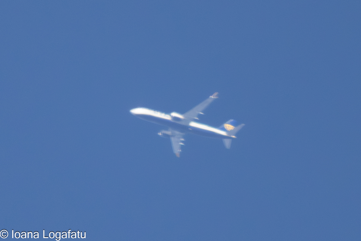 Airplane gliding through a clear blue sky